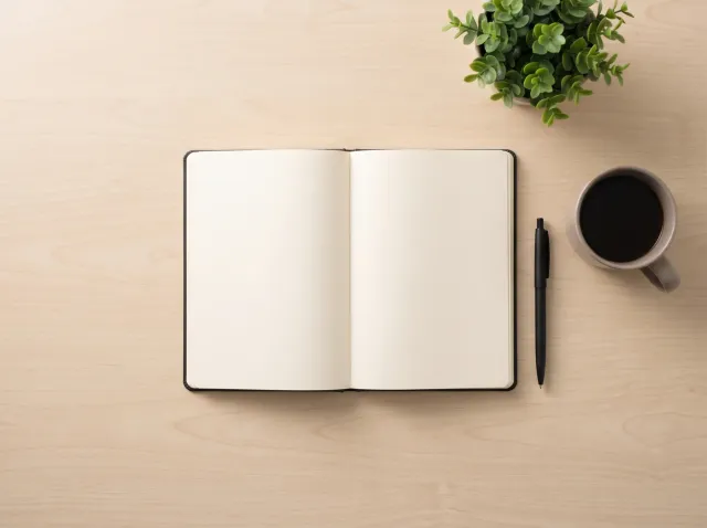 Agenda abierta sobre un escritorio, con un esfero y una taza de café